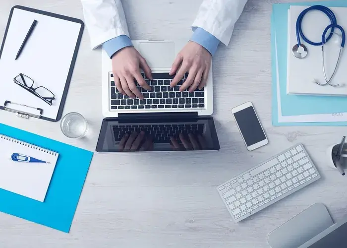 Médico digitando no notebook ao lado de estetoscópio, representando backlink em blog de saúde DA 58+